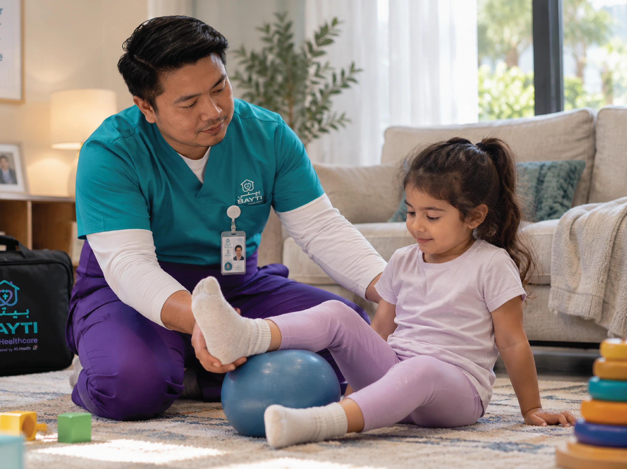 A physiotherapist and a young child reaching for a soft ball on a play rug